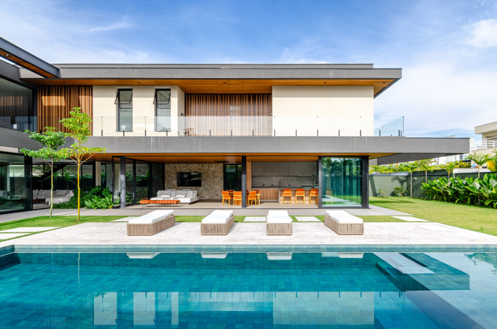 Fachada da Casa Sintonia com piscina e volume superior que parece flutuar sobre o terreno – projeto João Gobbo