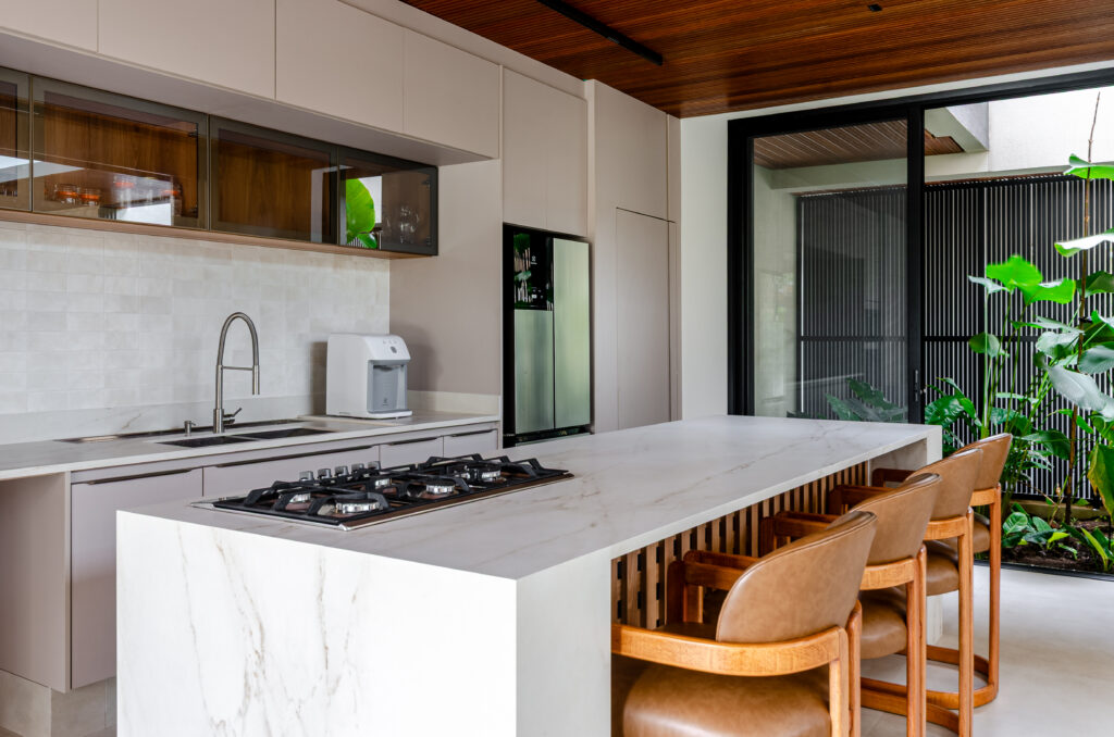 Cozinha com ilha em pedra clara e marcenaria sob medida Madecor – Casa Sintonia